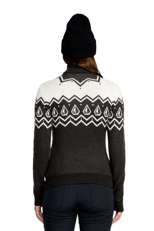 Person wearing a black and white patterned sweater with a black beanie on a white background