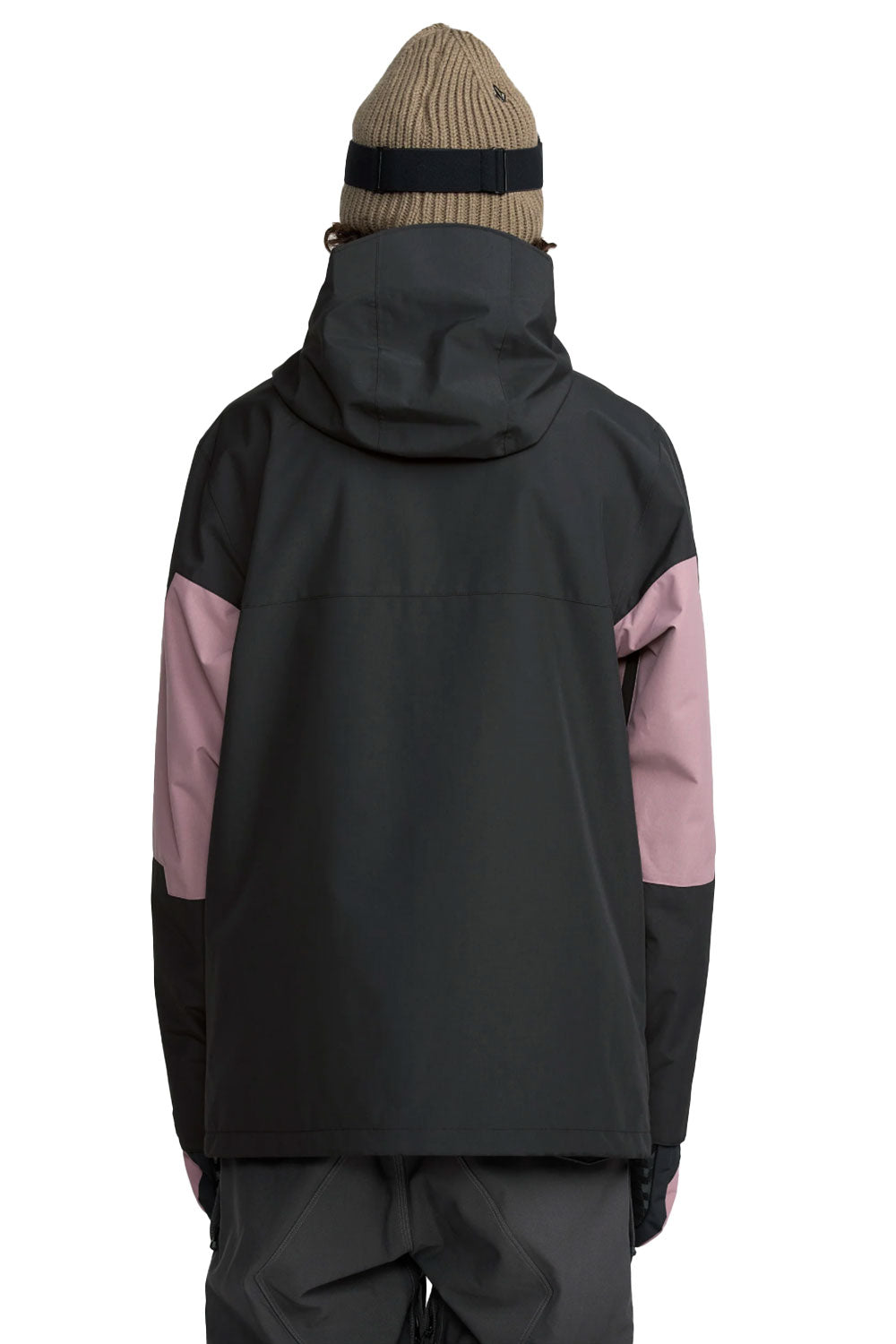 Person wearing a black and pink jacket with a beige beanie on a white background