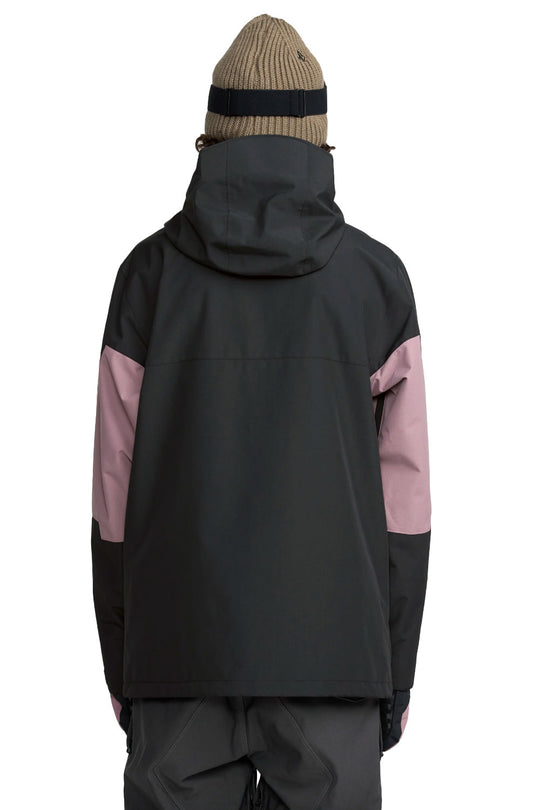Person wearing a black and pink jacket with a beige beanie on a white background