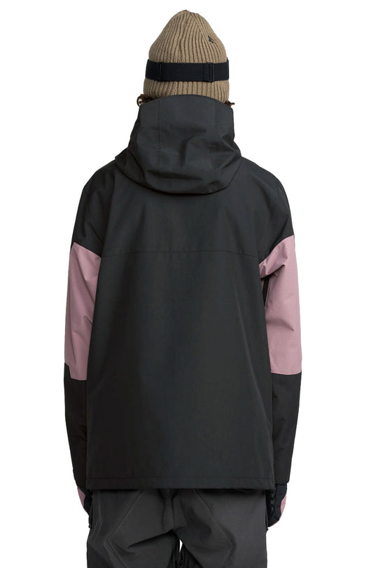Person wearing a black and pink jacket with a beige beanie on a white background
