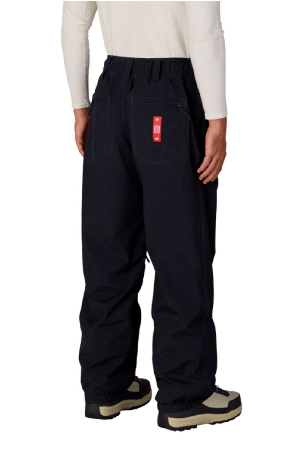 Black snow pants with a red patch on a white background