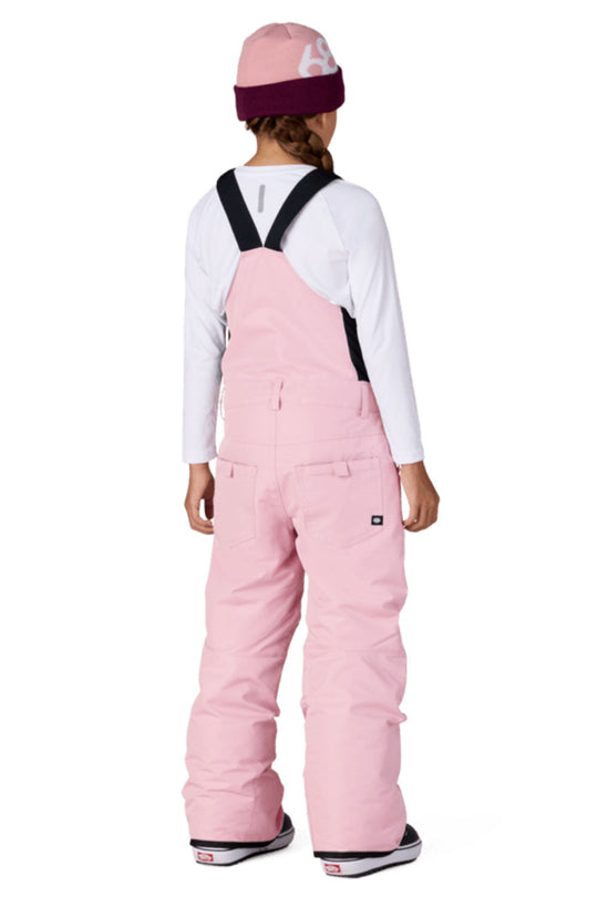 Person wearing pink snow pants with suspenders on a white background