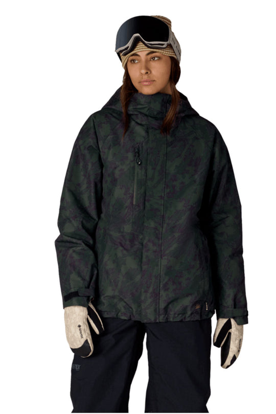 Person wearing a dark green camouflage snow jacket, black pants, and white gloves on a white background