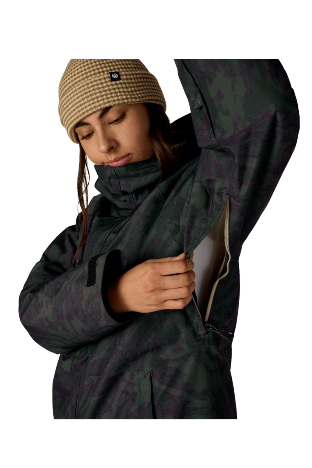 Person wearing a dark coat and checkered beanie on a white background