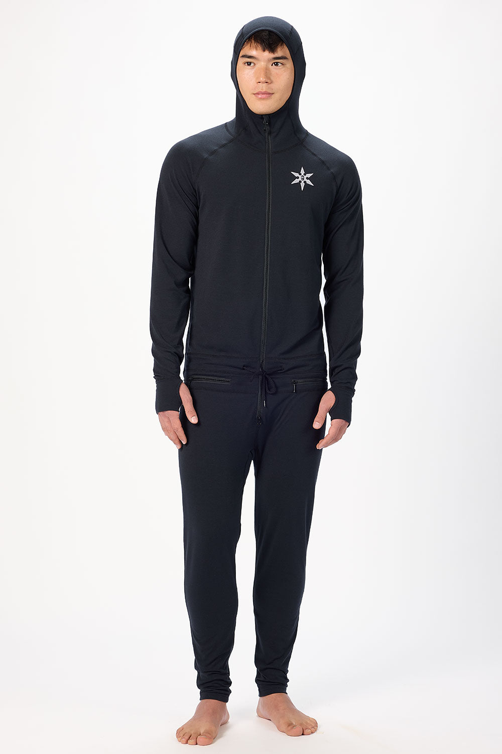 Person wearing a black hoodie and pants with a logo on a white background