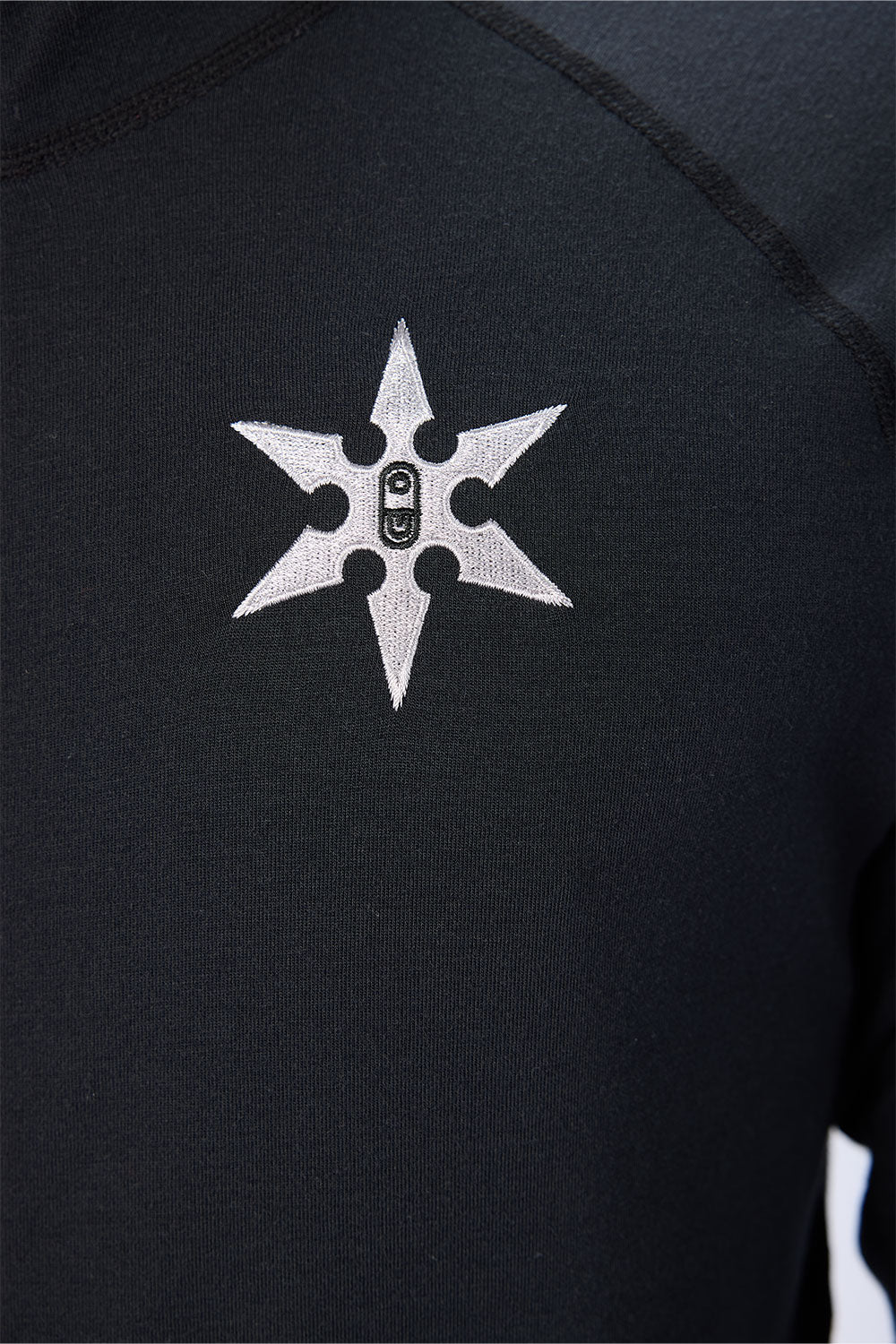 Black shirt with a white embroidered symbol on the chest