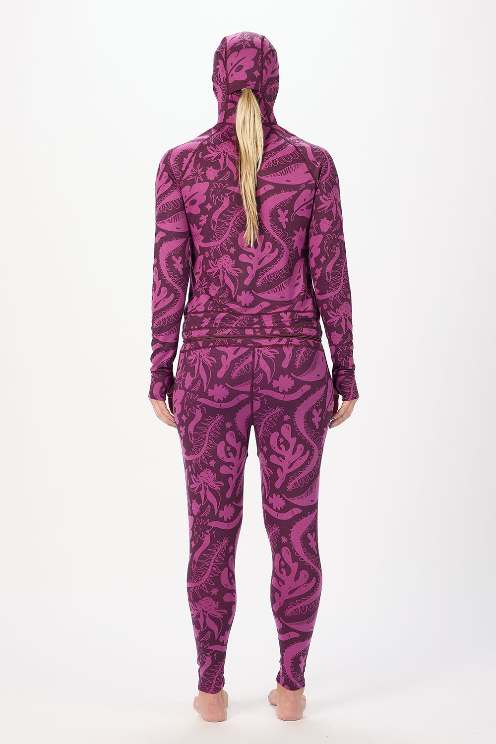 Person wearing a purple patterned hoodie and leggings set on a white background