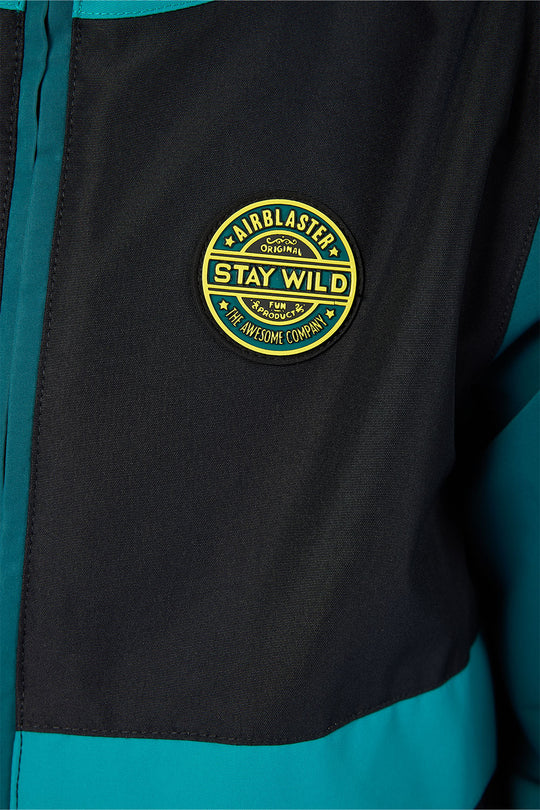 Close-up of a black and teal jacket featuring a circular yellow and black 'Airblasted Stay Wild' patch on the chest.