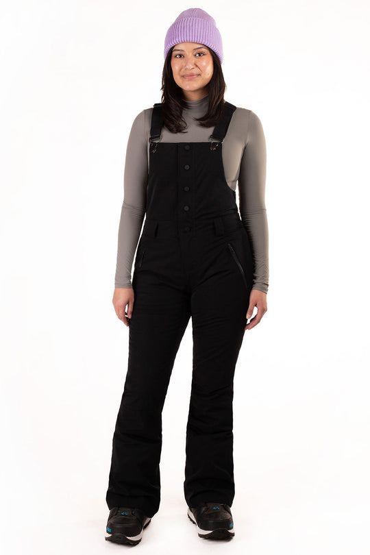 Person wearing black snow pants and a purple beanie on a white background