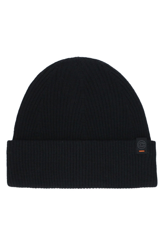 A black ribbed knit beanie hat with a folded cuff, featuring a small circular logo patch on the side.