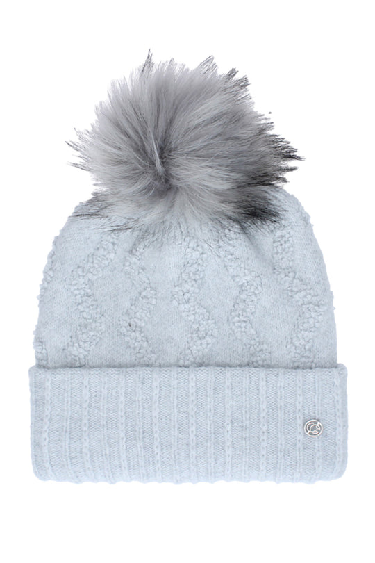 A light blue cable-knit beanie with a ribbed cuff and a fluffy gray pom-pom on top, shown against a plain white background.