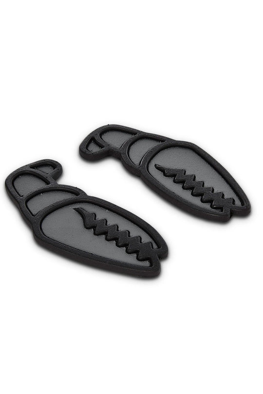 A pair of black rubber claw-shaped stomp pads with a textured, ridged design, displayed on a clean white background.