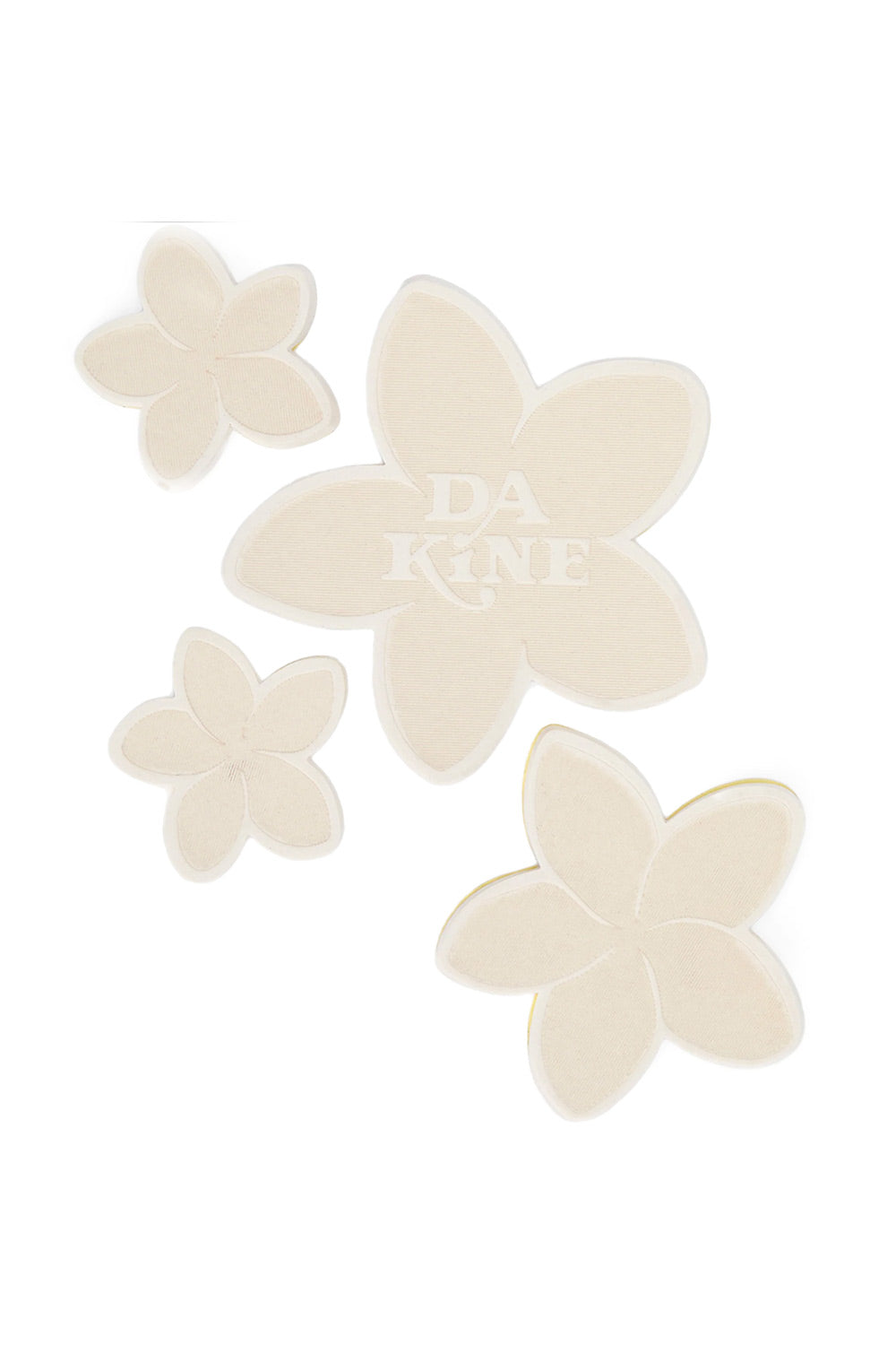 Four cream-colored flower-shaped stomp pads with five petals, arranged on a solid white background. The center patch features a debossed watermark of the brand name 'DAKINE'.