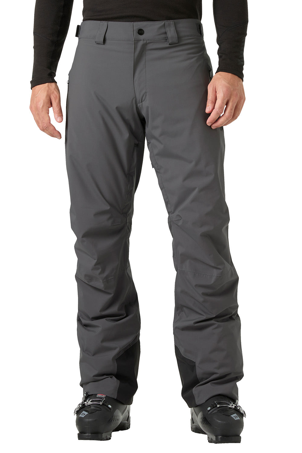 A person wearing dark gray ski pants with a black long-sleeve top and black ski boots, shown from the waist down against a plain white background.