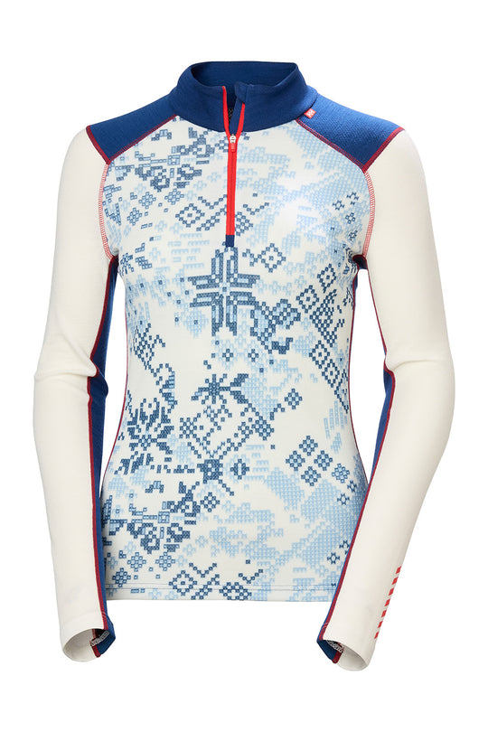A women's long-sleeve quarter-zip athletic top with a Nordic snowflake pattern. The top features an off-white body with a blue snowflake motif, navy blue shoulders and collar, and red zipper and piping accents.