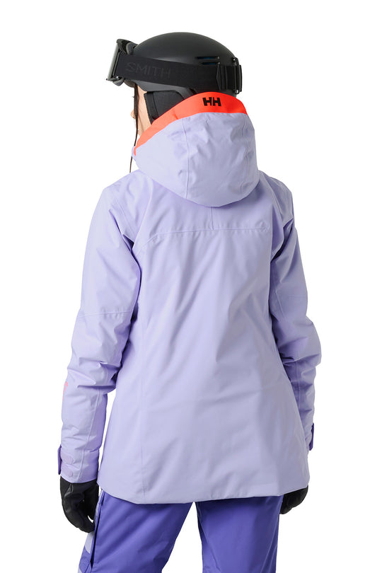A person shown from the back wearing a light lavender hooded ski jacket with a bright orange inner collar, a black helmet, and purple ski pants against a white background.