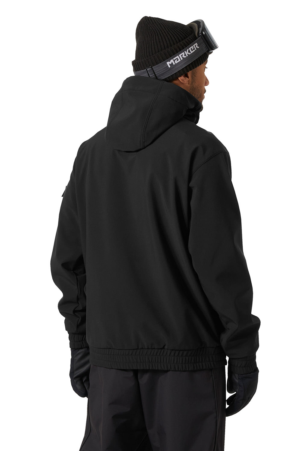 A person shown from the back wearing a black hooded jacket, black pants, black gloves, and a black beanie with goggles on a white studio background.