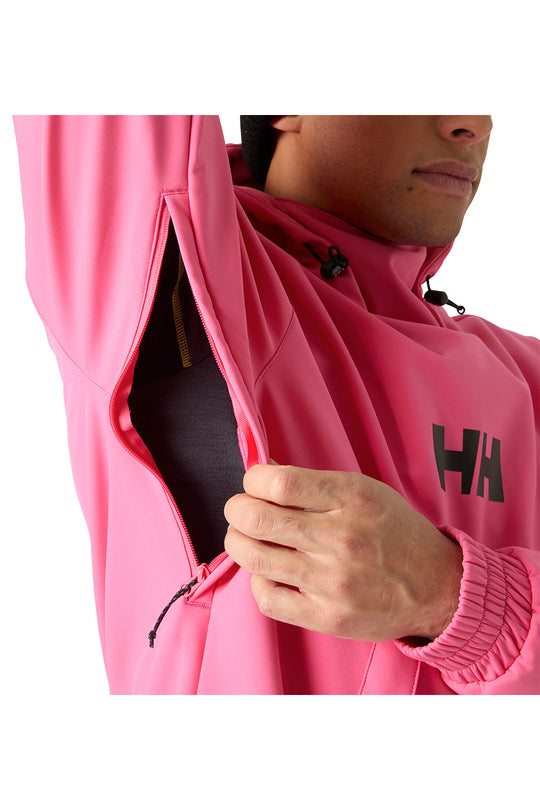 A close-up of a person wearing a bright pink hooded jacket, opening the left sleeve to reveal a dark inner layer. A black Helly Hansen 'HH' logo is visible on the chest.