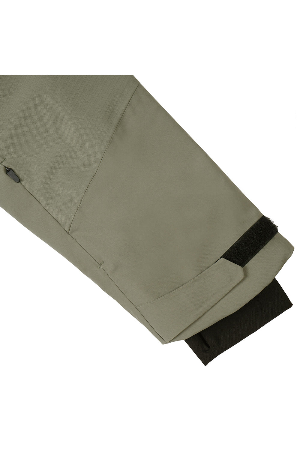 Close-up of a light olive green jacket sleeve showing a black inner cuff lining and a black hook-and-loop strap detail, on a white background.