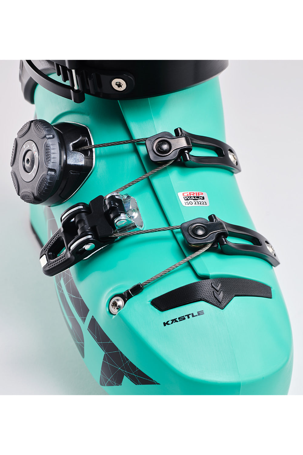 Close-up of a ski boot in a bright turquoise color with black buckles, straps, and branding details. The brand name 'KASTLE' is visible on the front of the boot.