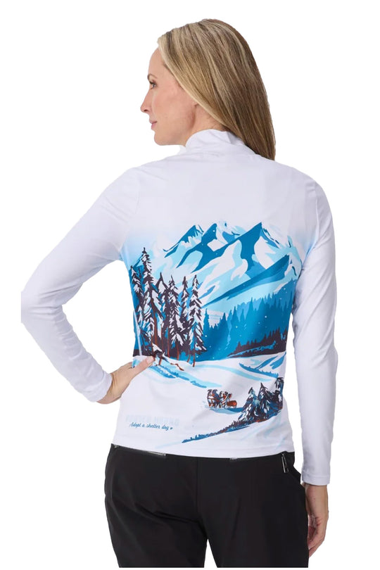 A woman shown from the back wearing a white long-sleeve athletic top with a large blue mountain and snowy forest graphic printed across the back.