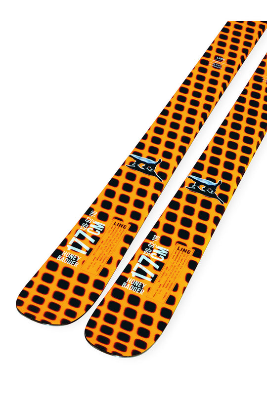Orange and black patterned skis with branding on a white background