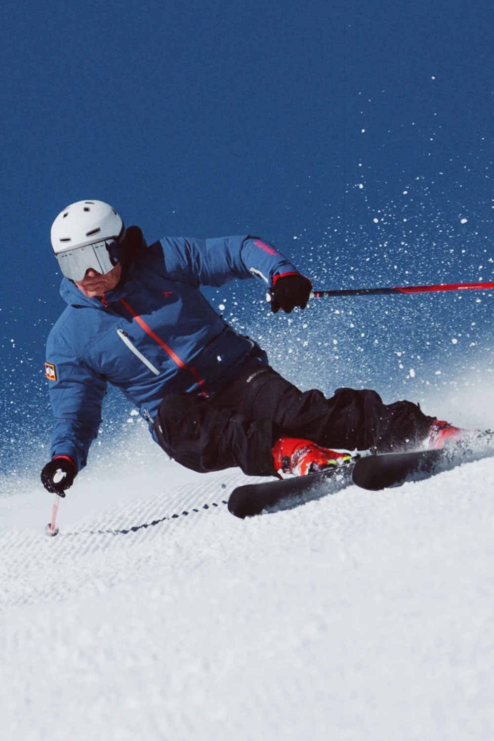 Skier in action on a snowy slope with a blue sky background