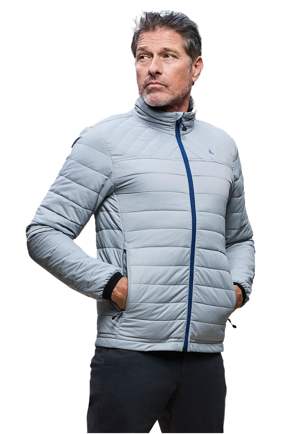A man wearing a light gray quilted puffer jacket with a dark blue front zipper, standing against a plain white background.