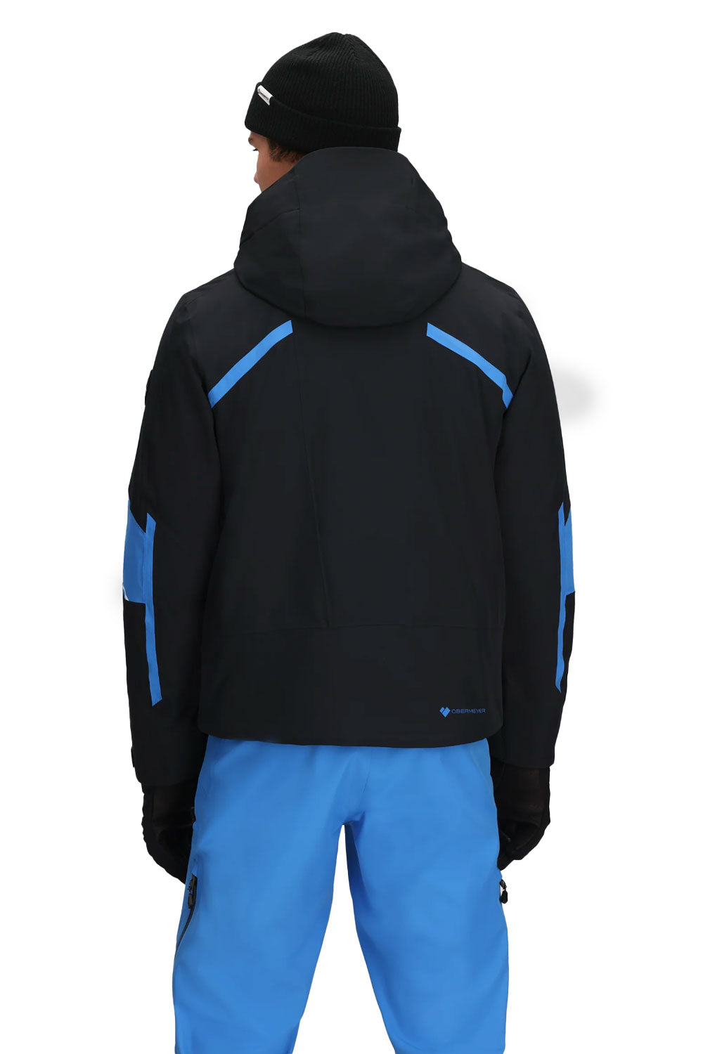 Person wearing a black jacket with blue accents and blue pants on a white background