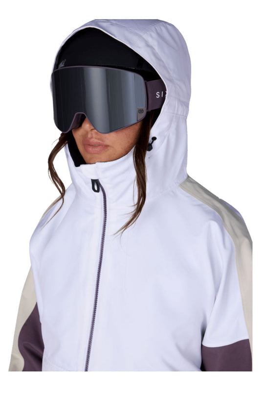 Person wearing a white  & purple 
ski jacket with a hood and goggles on a white background