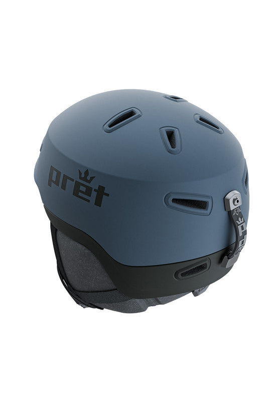 A matte slate blue ski helmet with a black chin strap and the Pret brand logo printed on the side, shown against a plain white background.