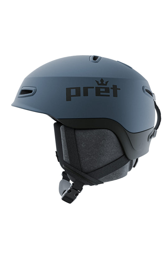 A matte slate blue ski helmet with a black printed 'pret' logo and crown icon on the side, shown from a three-quarters perspective against a solid white background.