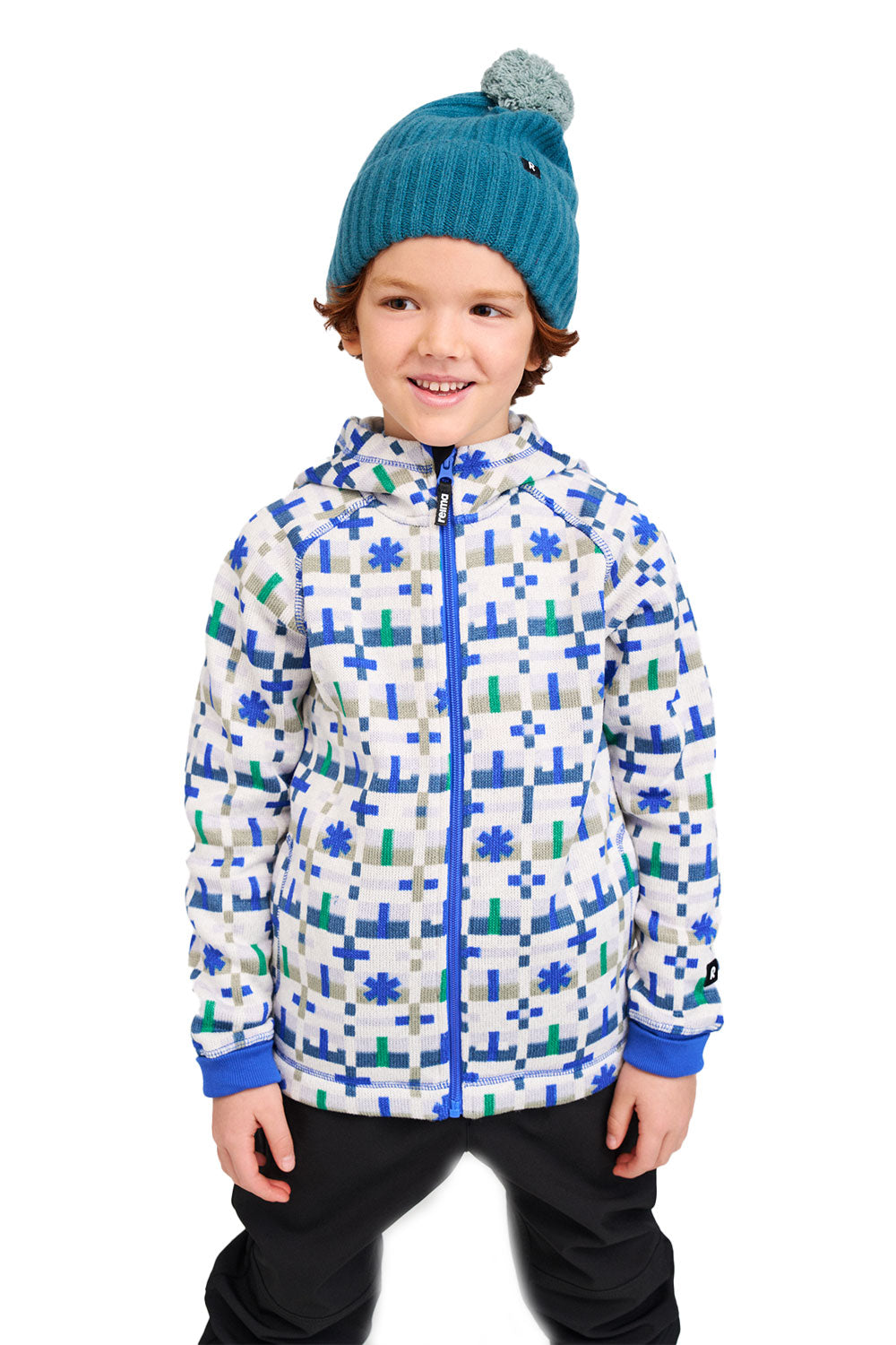 Child wearing a colorful jacket and blue knit hat on a white background