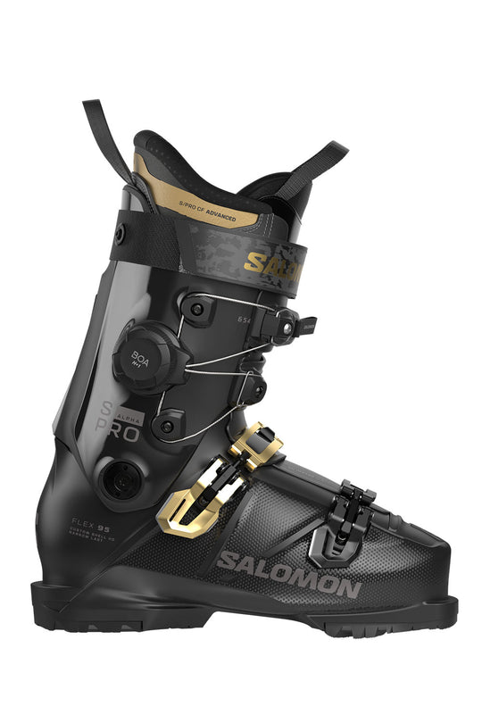 Black ski boot with gold accents on a white background