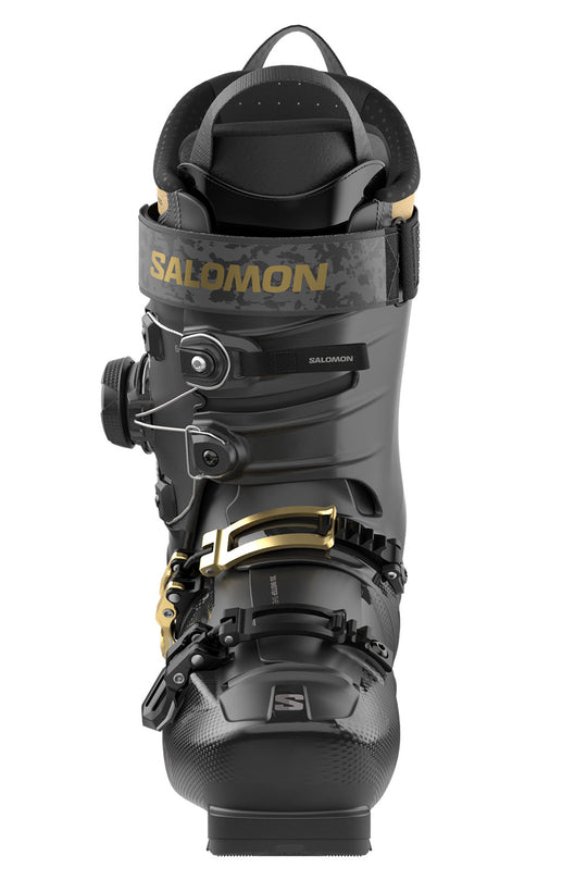 Black ski boot with gold accents and Salomon branding on a white background