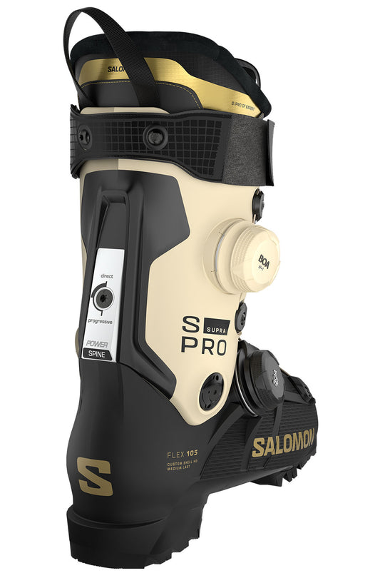 Salomon S Pro ski boot in black and cream with gold accents, featuring a dial closure system and a visible valve connector on a white background.