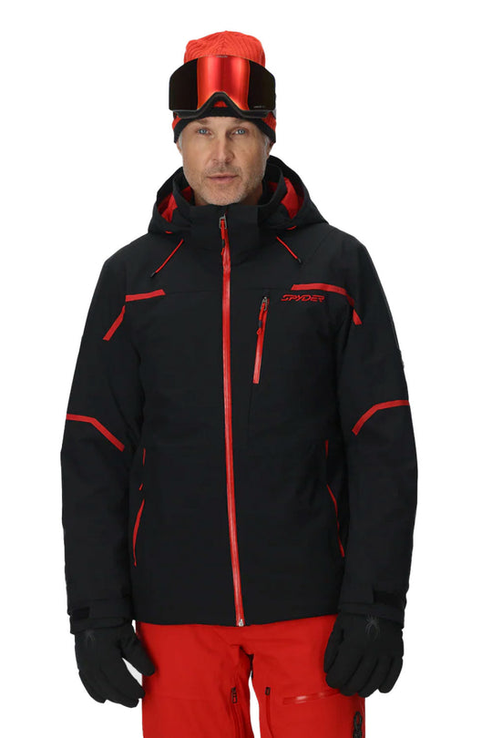 Person wearing a black and red ski jacket with goggles on a white background