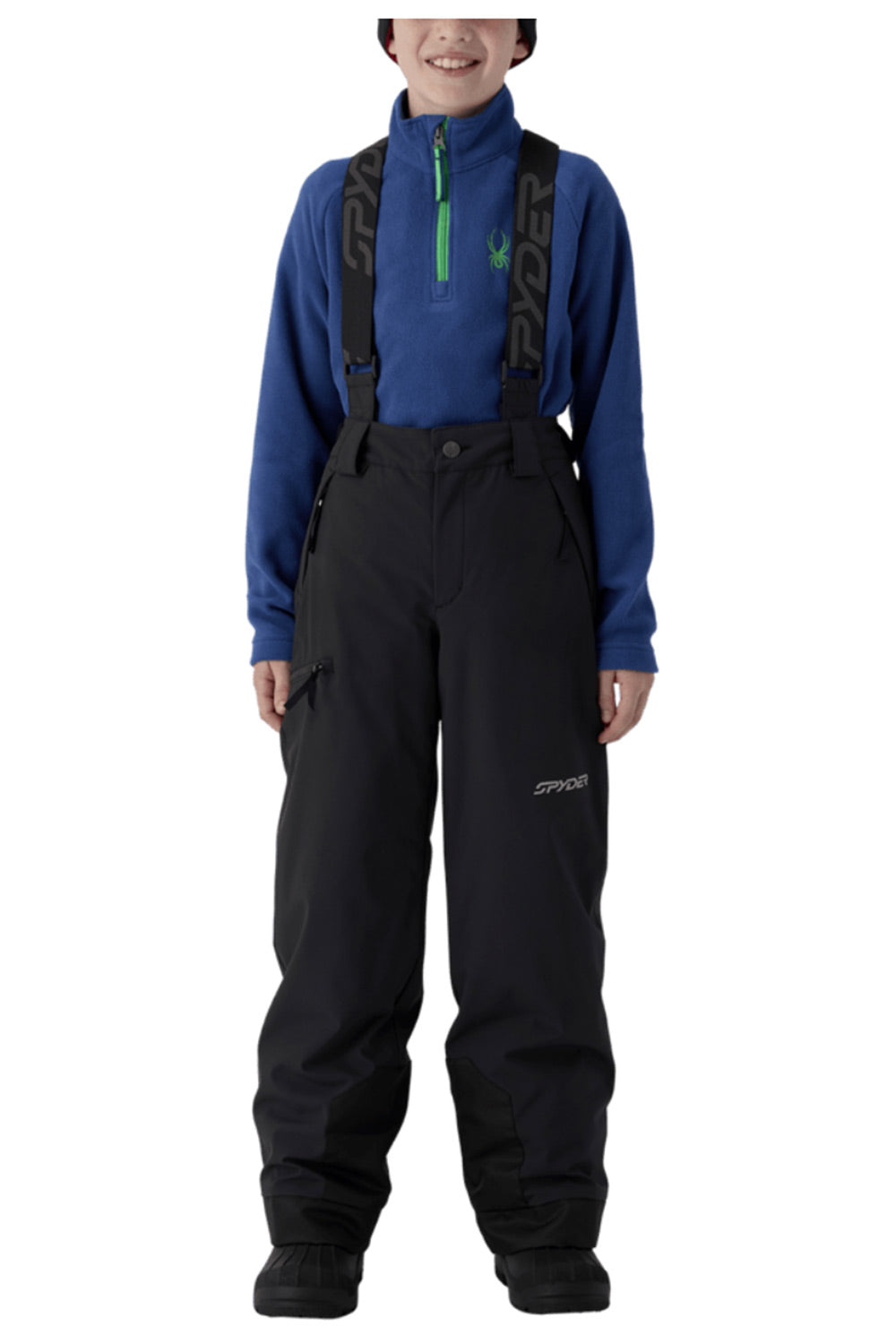 A child model wearing Spyder snow bib overalls in black with a blue quarter-zip fleece underneath, photographed against a plain white studio background.