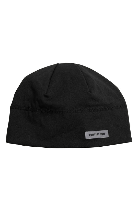 A black knit beanie hat with a small rectangular white brand patch on the front brim that reads 'TURTLE FUR'.