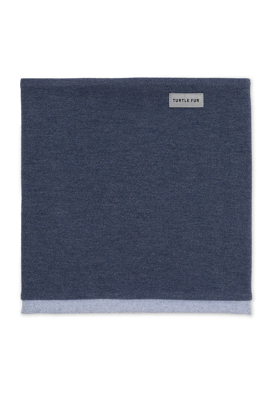 A dark navy blue knit neck warmer or scarf with a light gray ribbed hem and a small white 'TURTLE FOR' brand label on the upper right, shown flat against a white background.