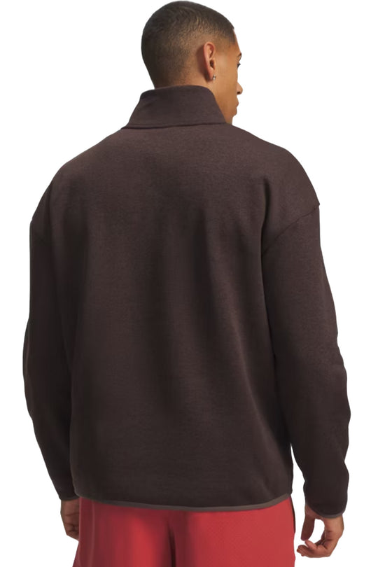 A man shown from the back wearing a dark brown quarter-zip fleece pullover and red pants, photographed against a solid white background.