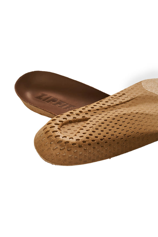 A close-up of a tan perforated shoe insole with a brown footbed, showing the brand name 'ZIPFIT!' printed on the footbed, set against a plain white background.