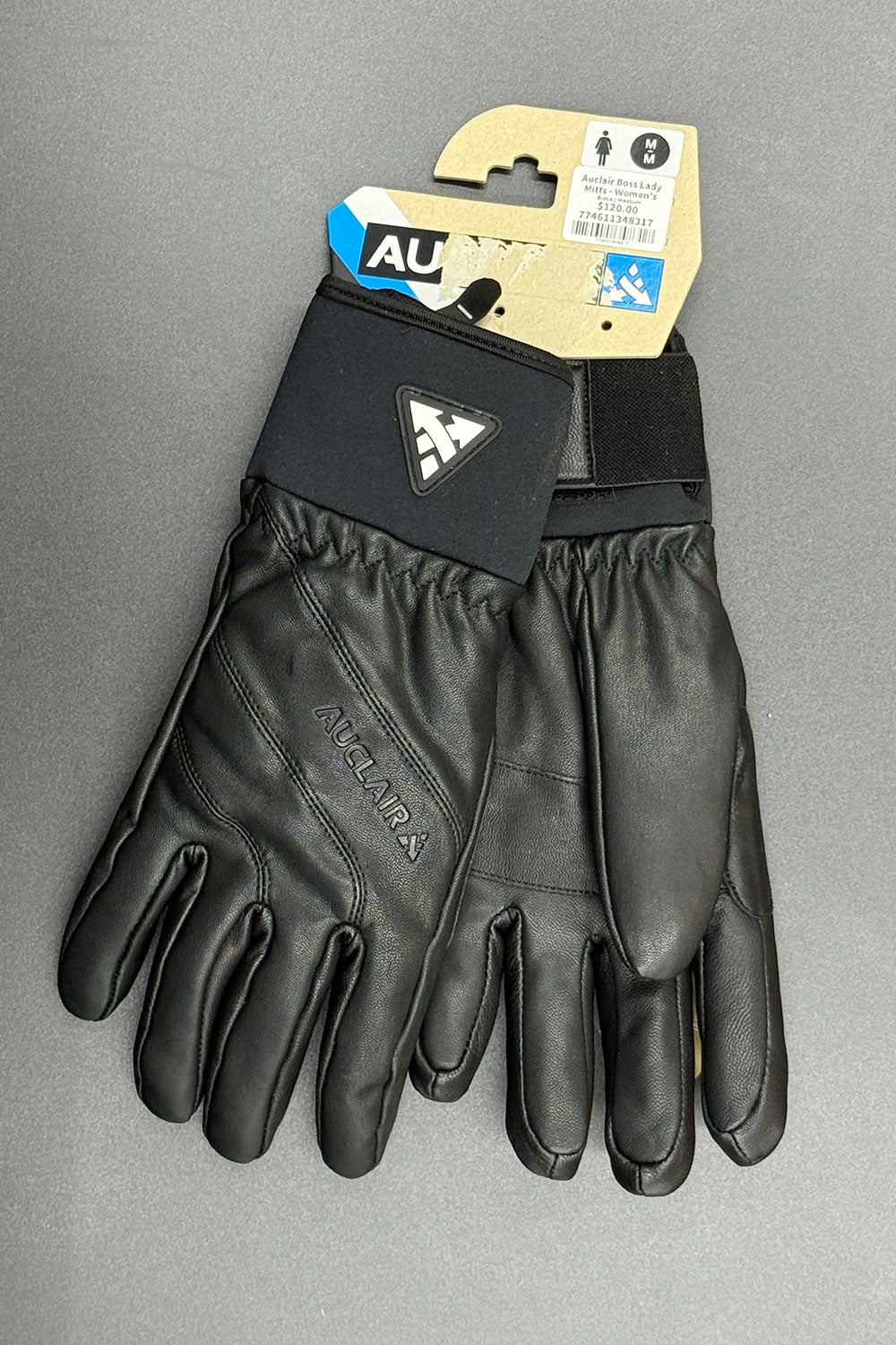 Black glove with a brand tag on a gray background