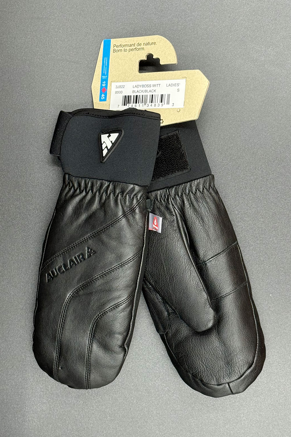 Black leather mittens with a brand tag on a gray background