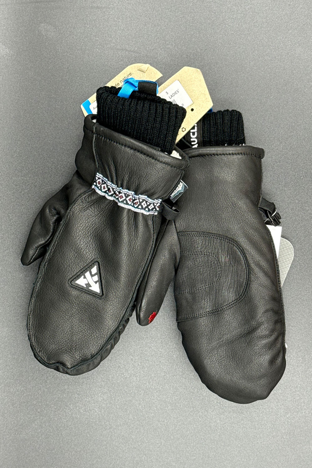 Black leather mittens with a brand logo on a gray background