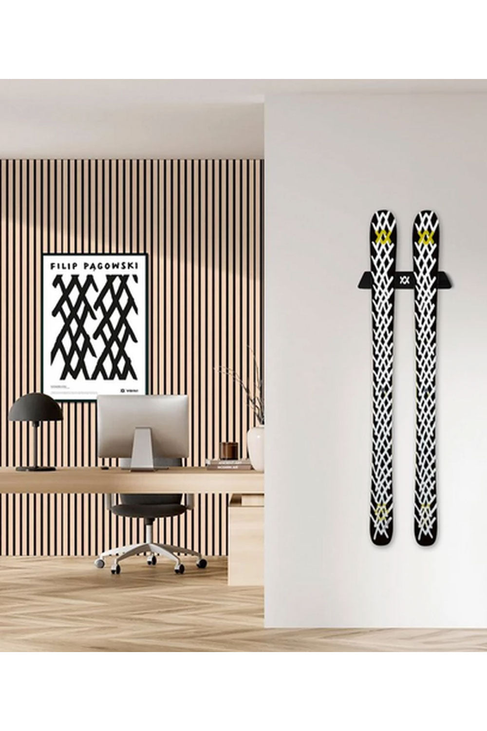 Two skis with black and white patterns on a wall next to a modern office setup.