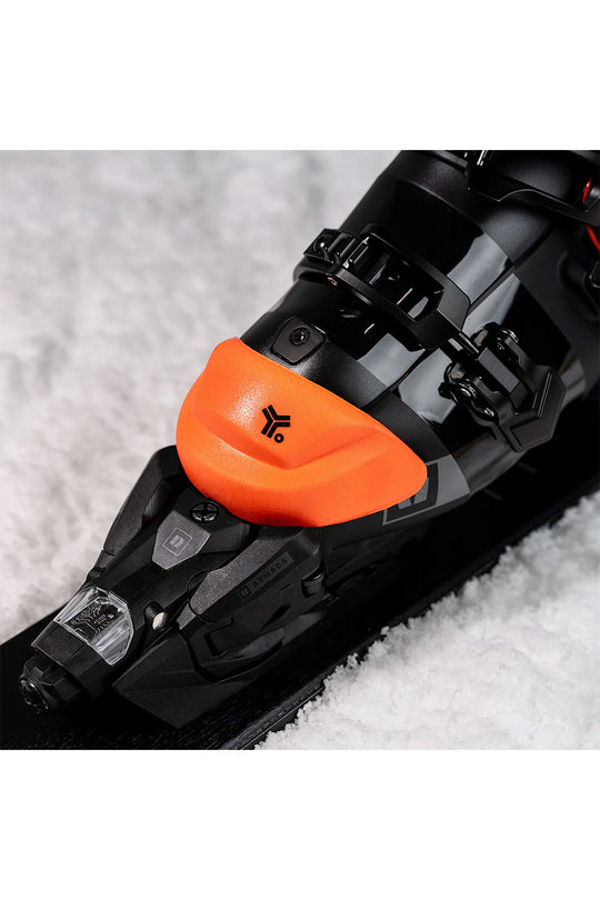 Close-up of a ski boot with an orange counter on a snowy background