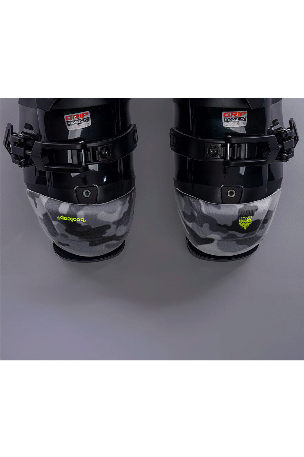 Black ski boots with camouflage pattern on a gray background