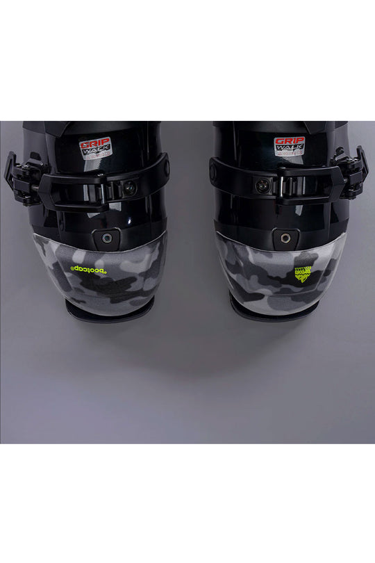 Black ski boots with camouflage pattern on a gray background