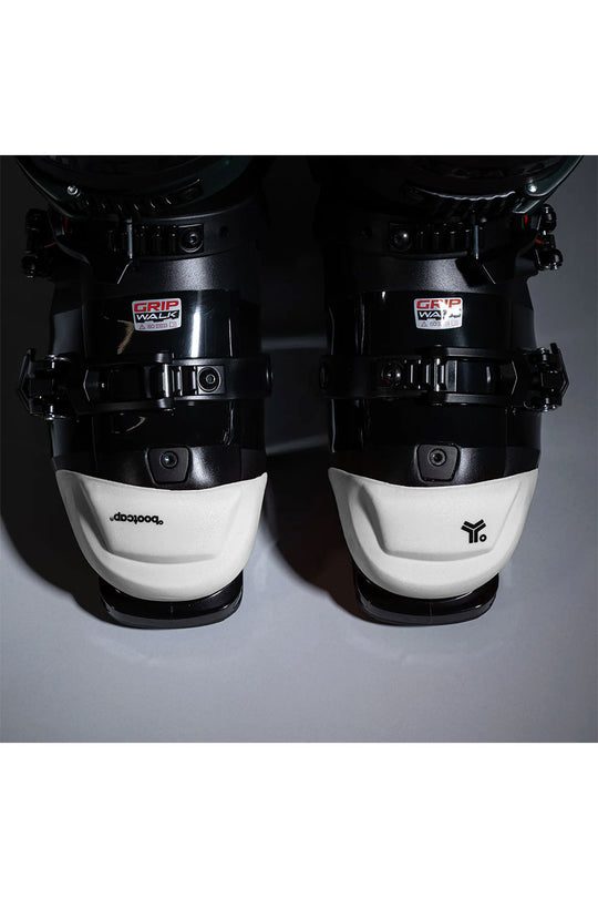 Pair of black and white ski boots on a gray background